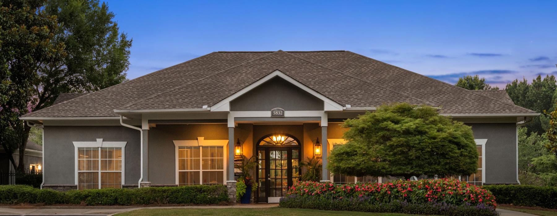 a club house with landscaping and a parking lot