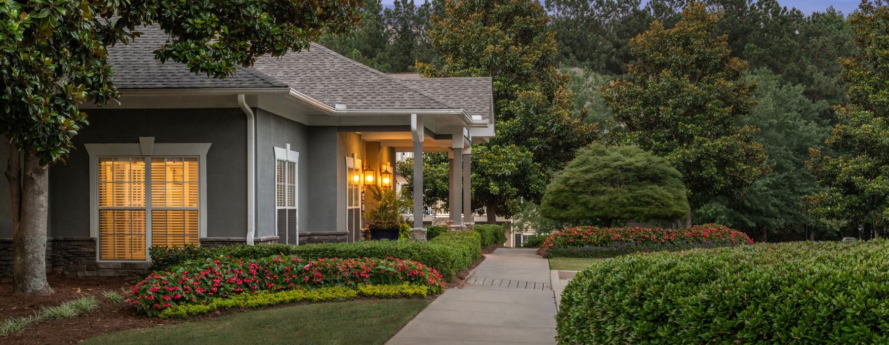 a walkway next to a building with landscaping